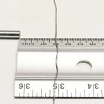 10 kt white gold chain lying on a flat surface, 30 mm from a strong rare earth magnet – not attracted to the magnet